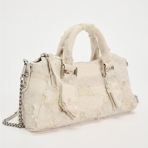 Distressed fabric city bag. Handles. Zip closure.